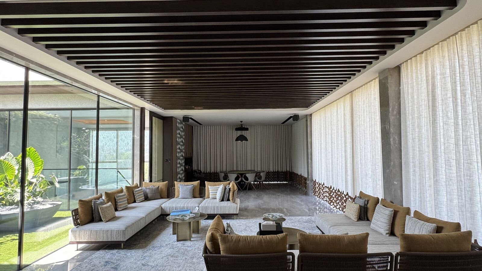 Open-plan living room with automated drapery and architectural lighting at the Kataria Residence